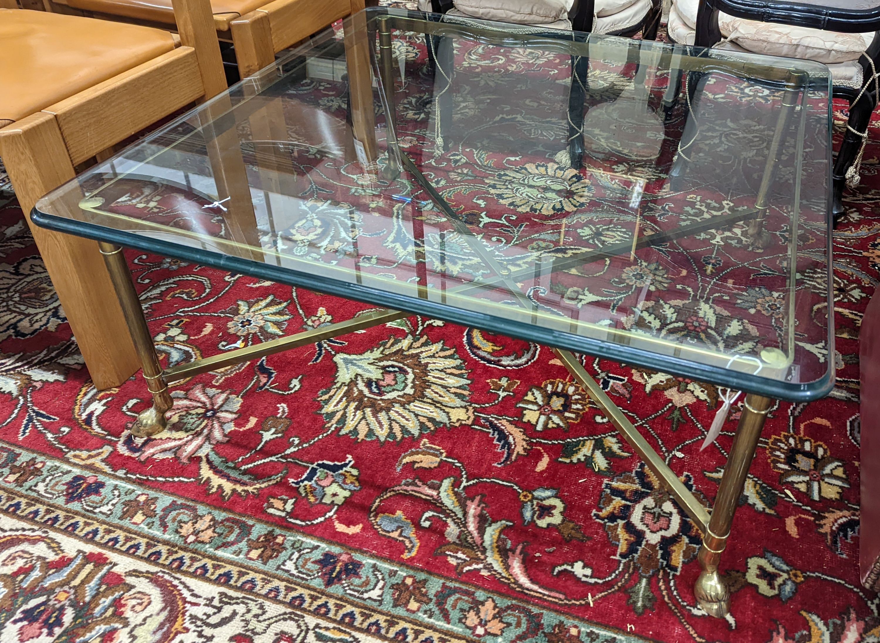 A Maison Jansen style square glass top brass coffee table on hoof feet, width 95cm, height 40cm